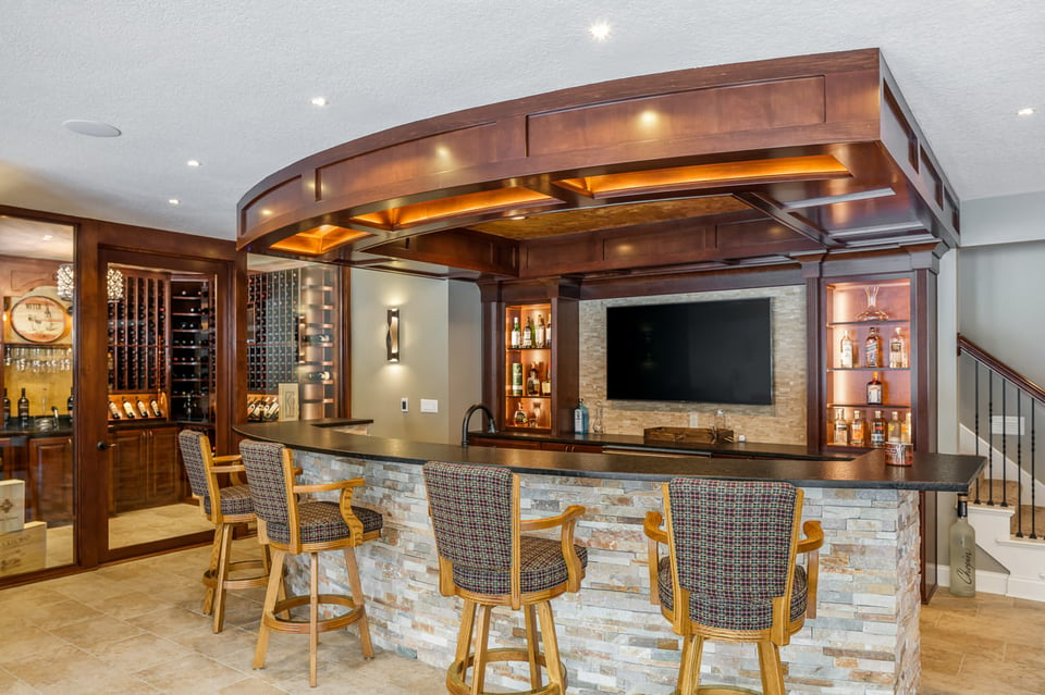 a basement bar fitted with bar stools and mini wine cellars