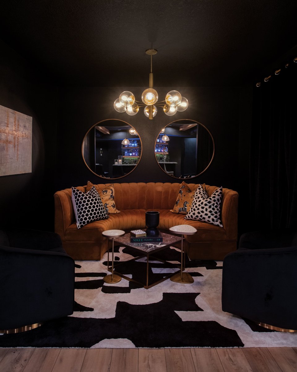 Nightclub-themed sitting area in a basement bar with two large mirrors reflecting the main bar shelf.