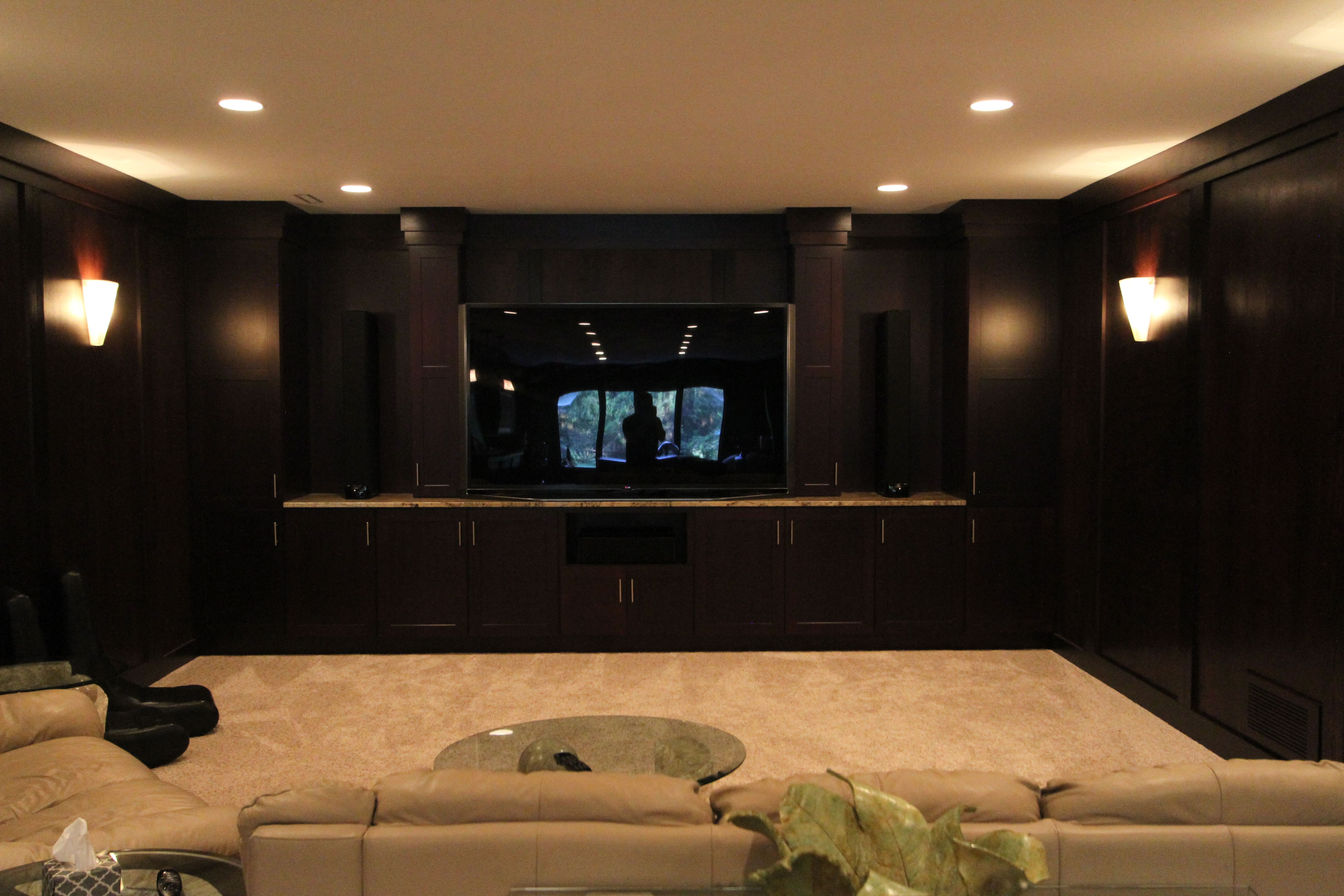 Warmly-lit Home Theater In A Basement With Grey-Painted Ceiling And Black-Painted Walls