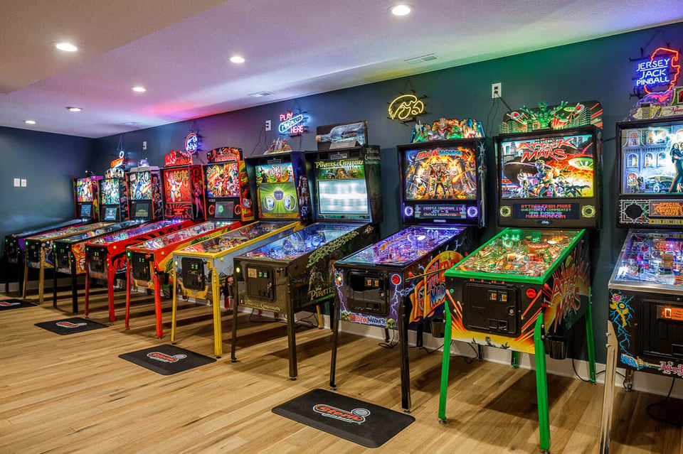 Pinball Playroom In A Basement. White And Grey Ceiling Painting Enhances Lightening In The Space