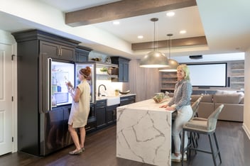 a modern basement bar with recessed lightening and island pendant lightening