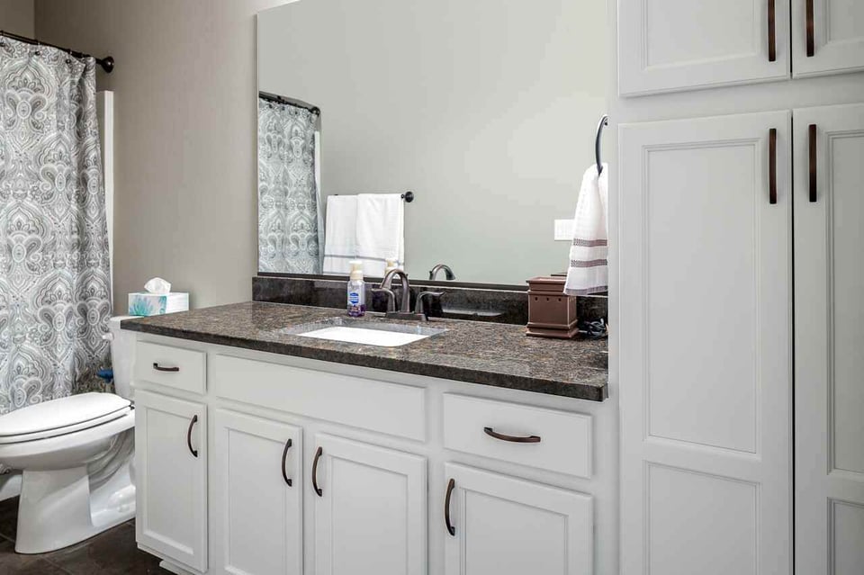 close up view of bathroom sink and toilet in a straight and narrow bathroom layout