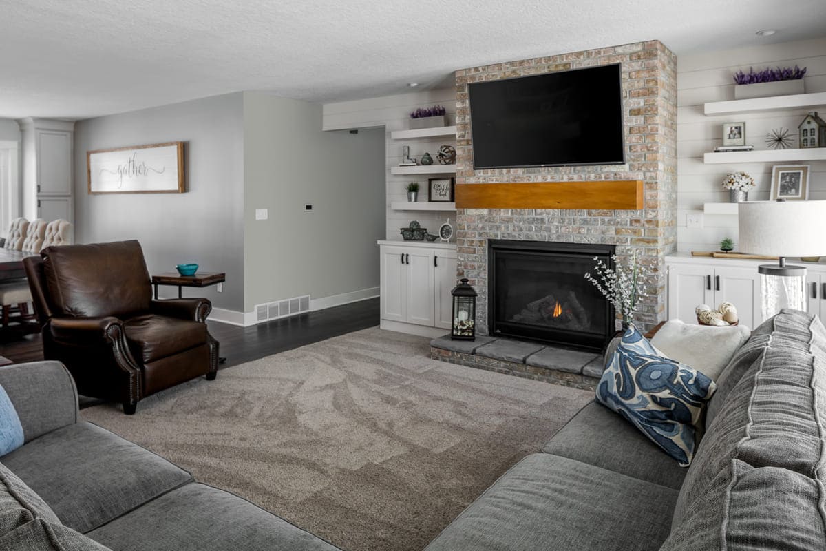 Whole Home Remodel Living Room with Fireplace Surrounded by Custom Built-Ins and Floating Shelves | Compelling Homes