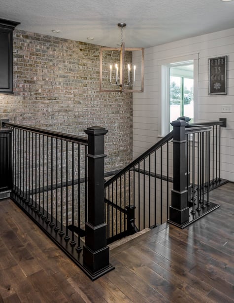 Whole Home Remodel with Stone Accent Wall Leading Downstairs with Modern Stair Railing and Shiplap Wall | Compelling Homes