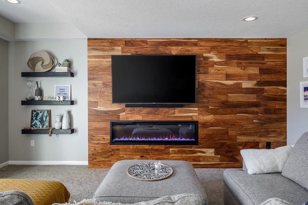 Basement Remodel Hardwood Flooring Accent Wall with Electric Built-In Fireplace and Floating Shelves Lots of Natural Light | Compelling Homes Remodeling & Design