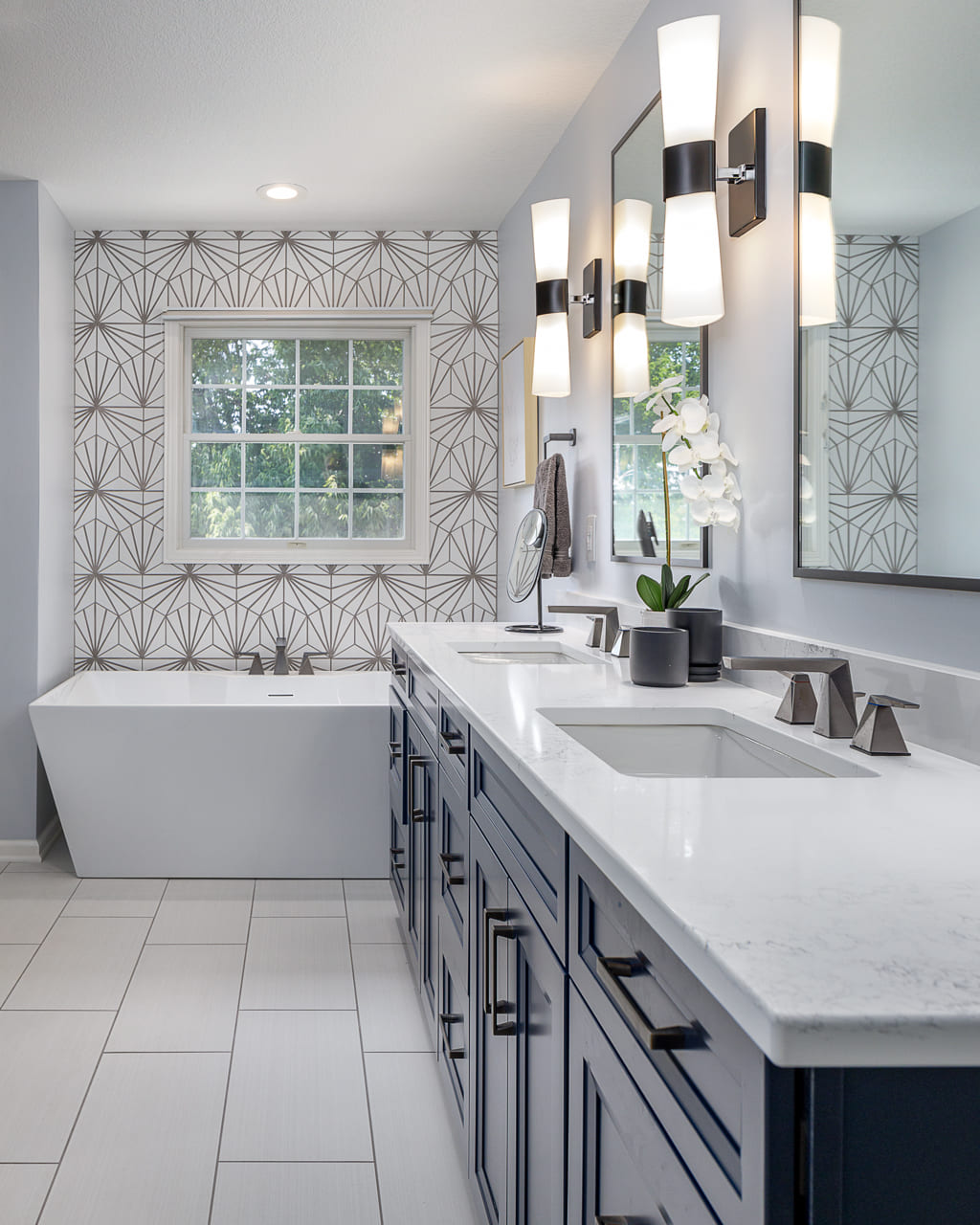 Art Deco Inspired Modern Bathroom with Double Sinks and Eye-Catching Wallpaper Behind Standalone Tub | Compelling Homes