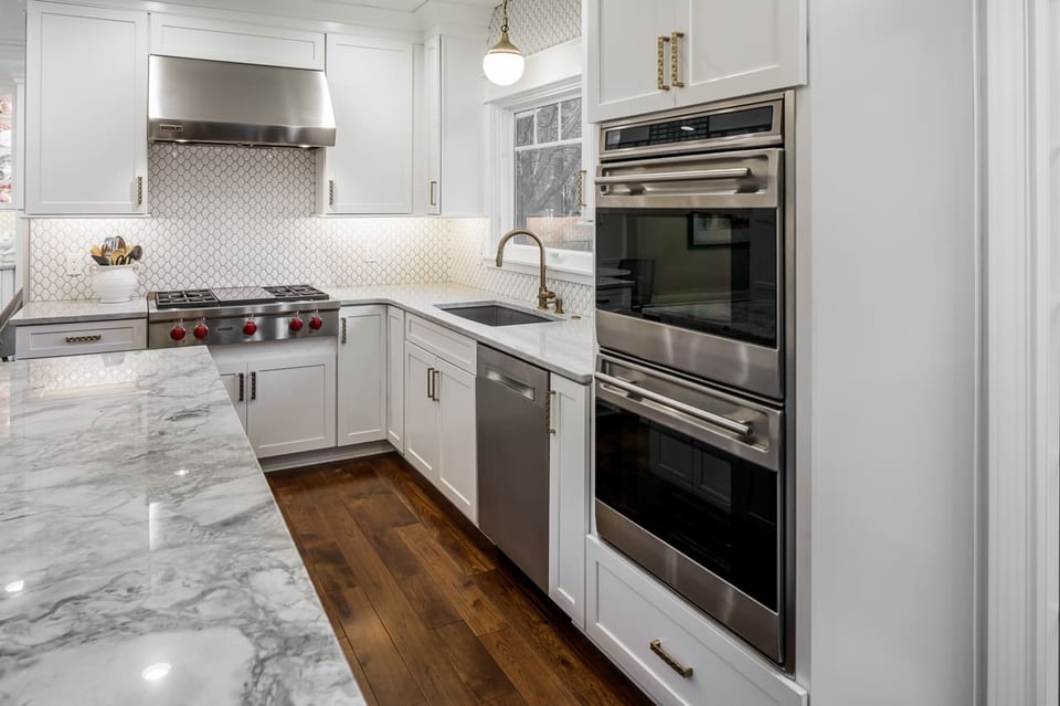 Built In Appliances and Quartzite Countertop at Eat In Kitchen Island with Rose Gold Kitchen Hardware | Compelling Homes Design-Build Experts in Des Moines, IA