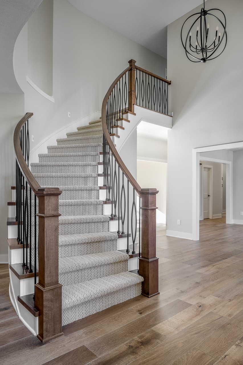 Wooden stairs flushed with carpet connecting living space to upper floor of a home