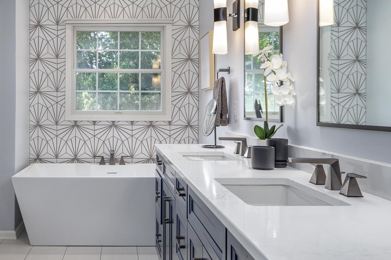 Art-Deco Inspired Modern Bathroom with Double Sinks and Eye-Catching Wallpaper Behind Standalone Tub | Compelling Homes